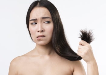 Jeune fille tenant les pointes de ses cheveux 